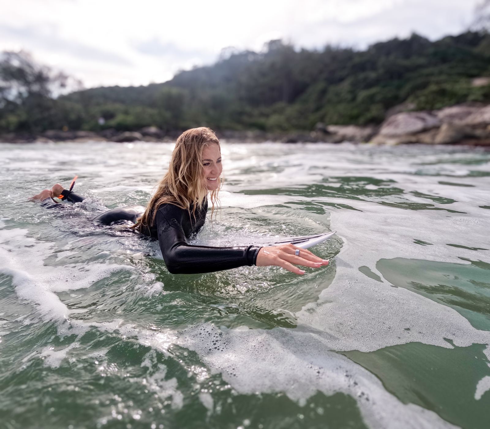 Surfista remando no mar usando o Mormaii Ring